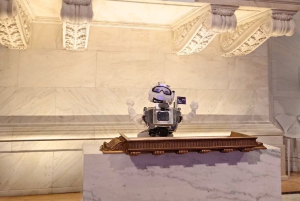 A robot from the robotics internship in Ecuador displayed on top of a podium.