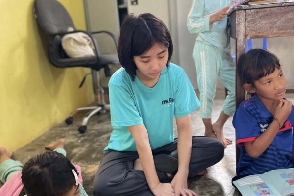 An intern reading along with the kids during her internship in public health in Cambodia.