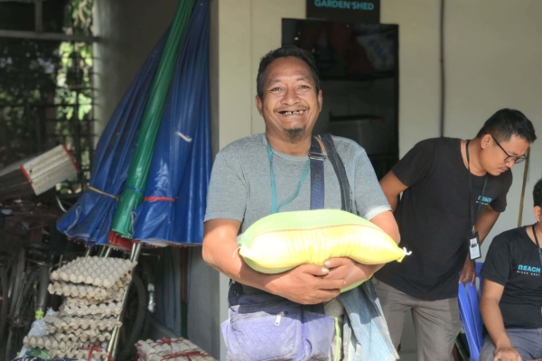 A man receiving a sack of rice in Cambodia