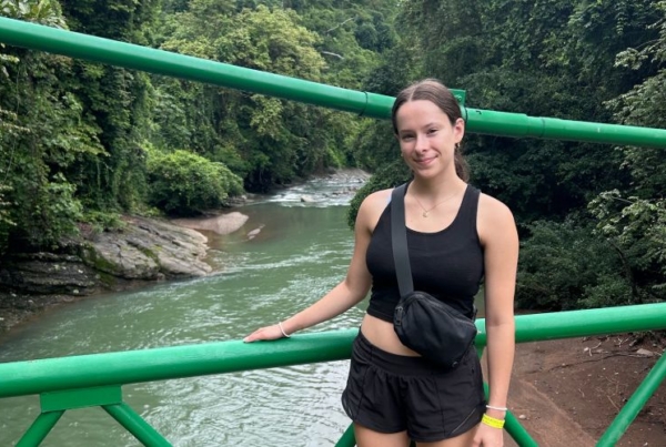 Kylie posing for a picture by the waterfalls while in her wildlife husbandry internship.