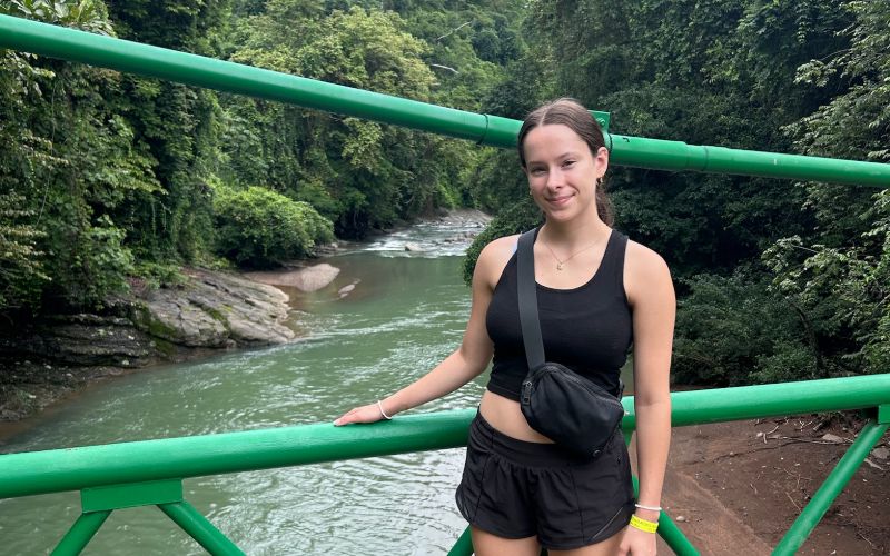 Kylie posing for a picture by the waterfalls while in her wildlife husbandry internship.