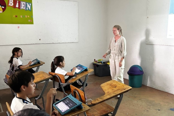 An intern instructing the students on what to do on their tablets.