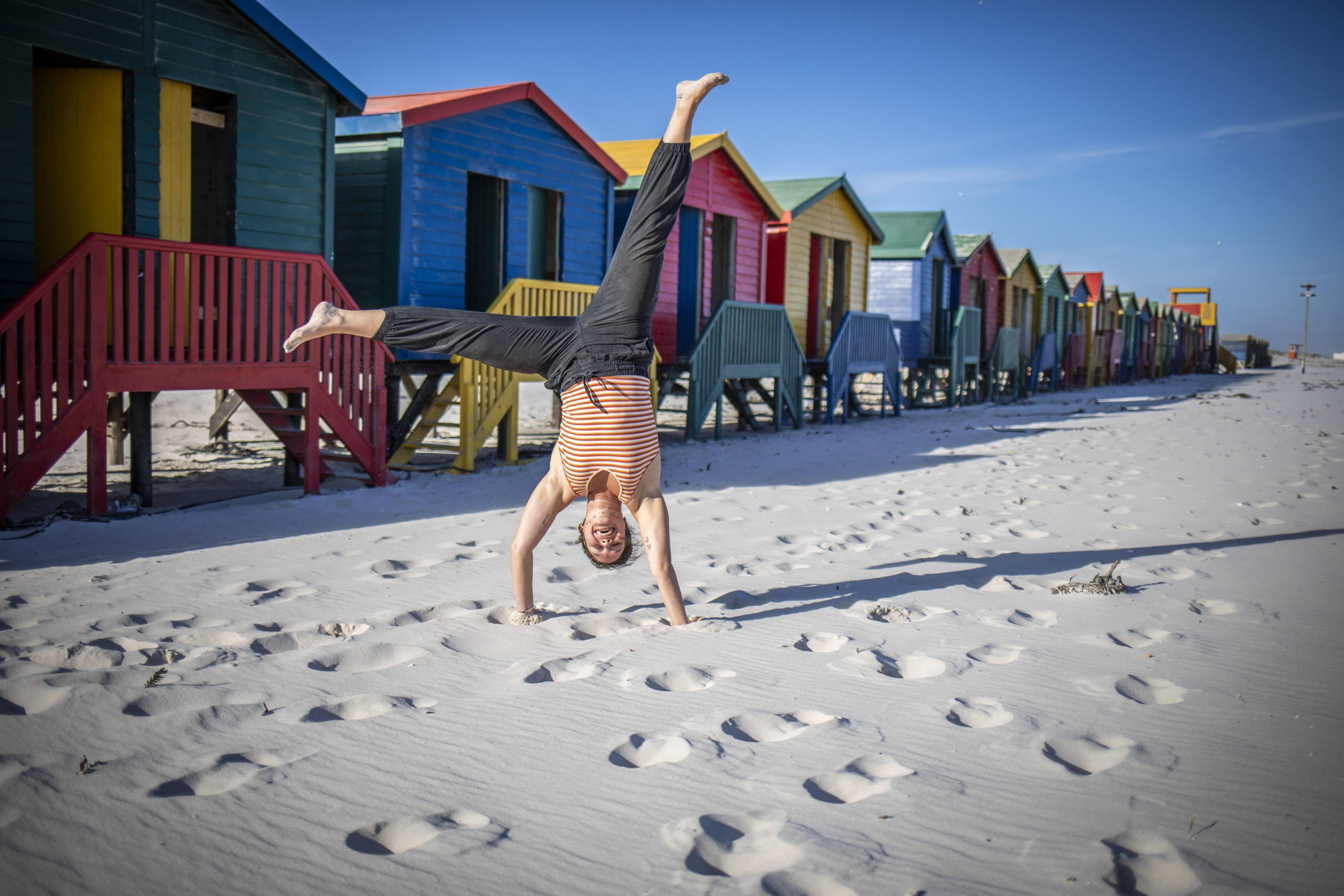 A happy intern doing a cartwheel on the sand.
