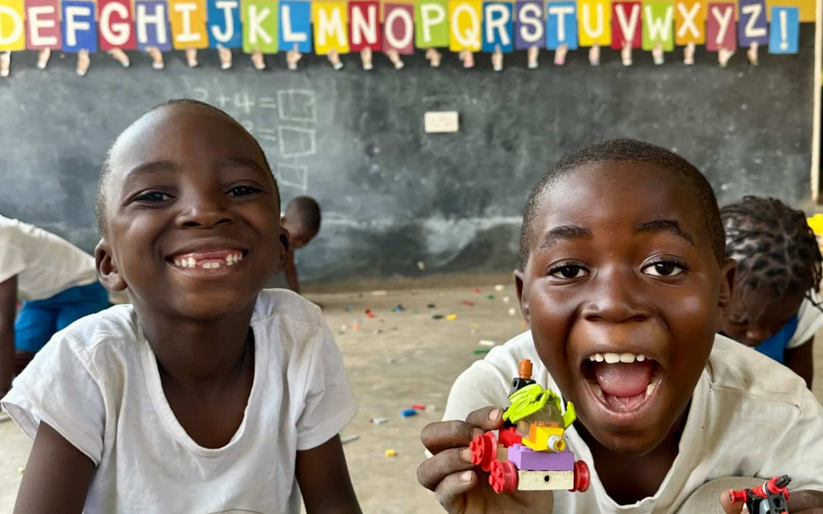 Two Zambian kids smiling for a picture.