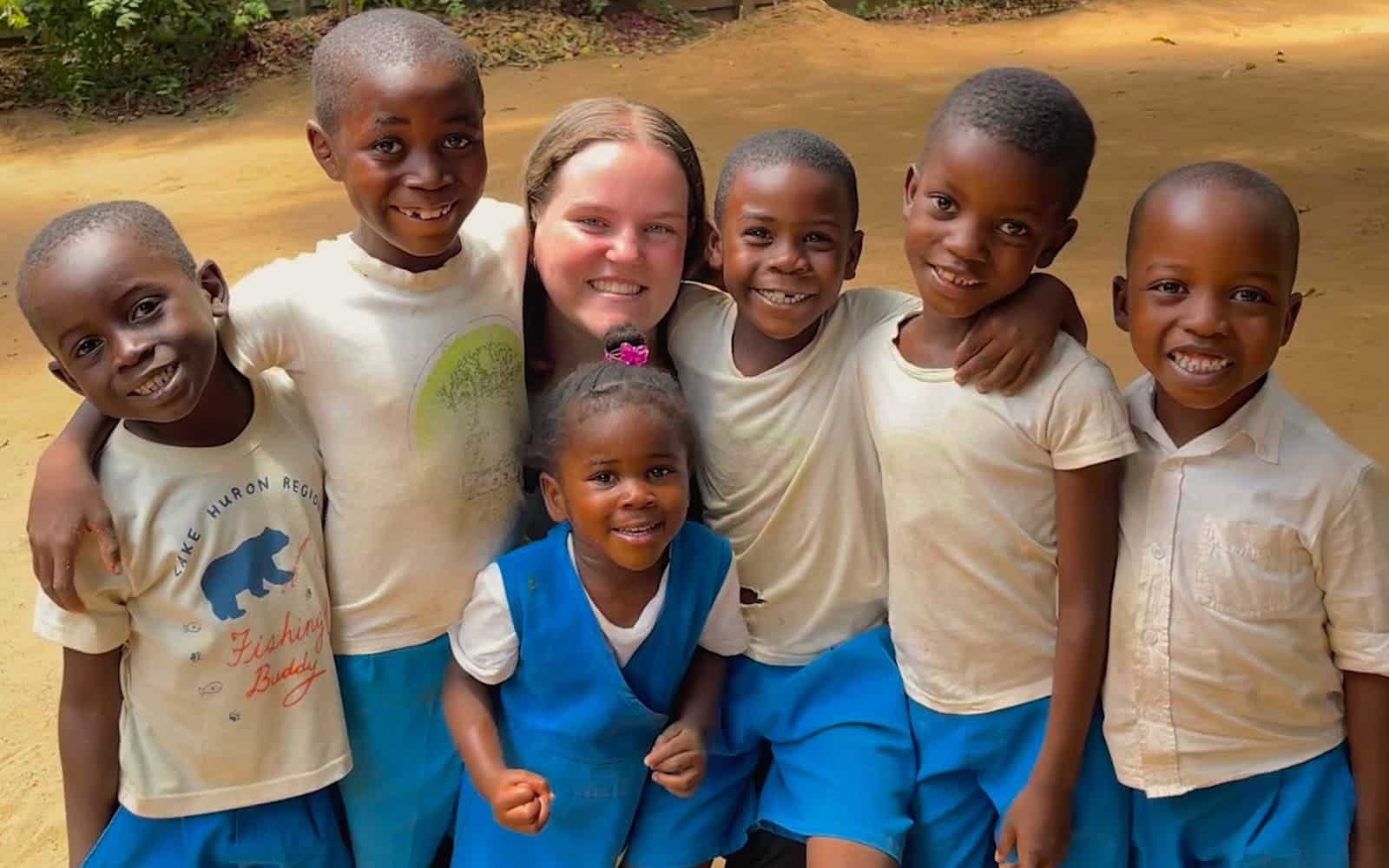 Annie Kelley posing for a picture with a group of kids whilst in her Female Empowerment Education Intenrship in Zambia.