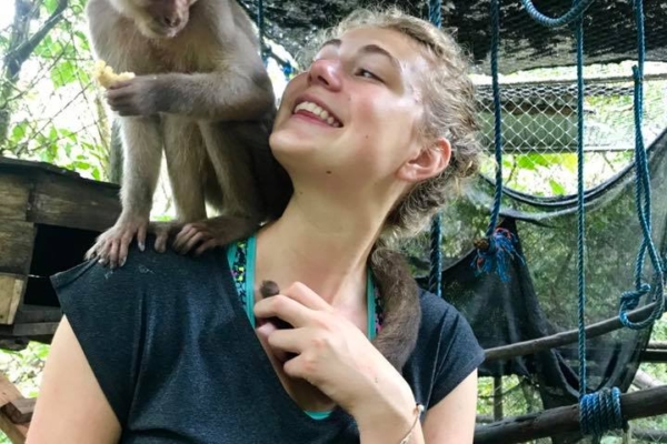 An intern posing for a picture with a monkey on her shoulder in Ecuador.
