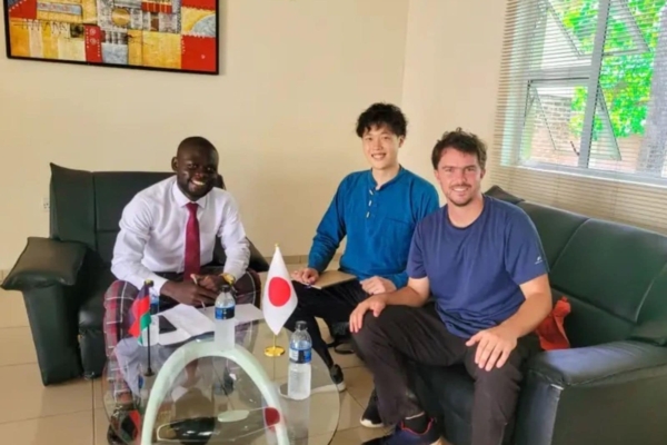 A pair of Gender Equality interns in posing for a picture with a local.