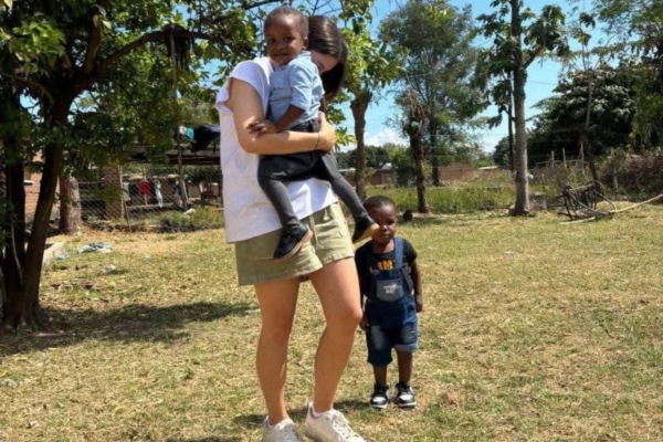 A Gender Equality intern carrying a child.