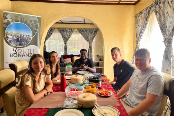 A group of interns alogn with the CEO of HYCF enjoying a meal together.