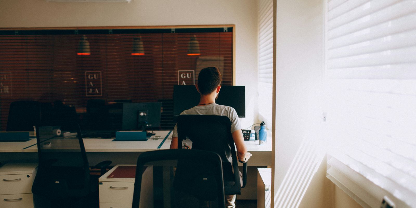 Man working at a desk with dual monitors