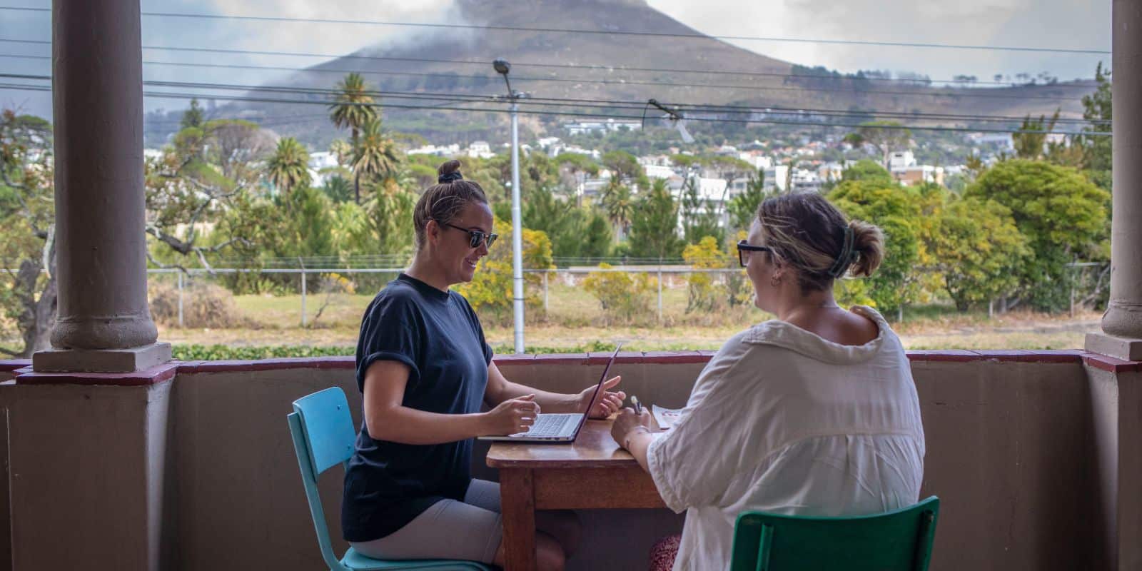 Two women working outside with a mountain view