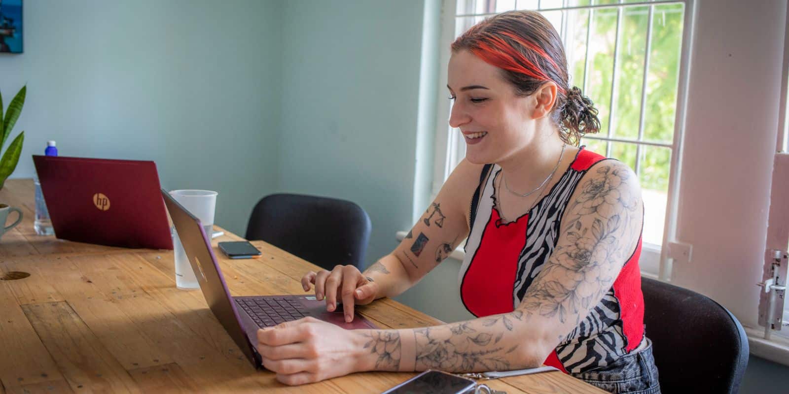 Smiling woman using a laptop at a table