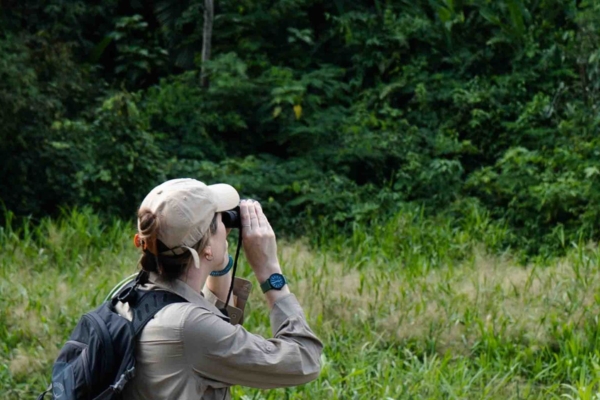 Intern observing wildlife in the Amazon Rainforest during a conservation internship in Peru.