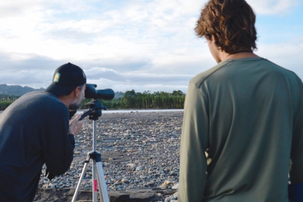 Interns monitoring wildlife along a river in the Peruvian Amazon.
