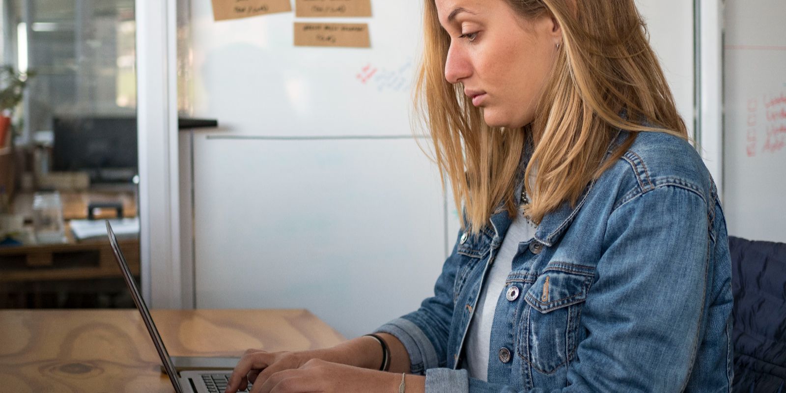 a woman typing on a laptop at a desk