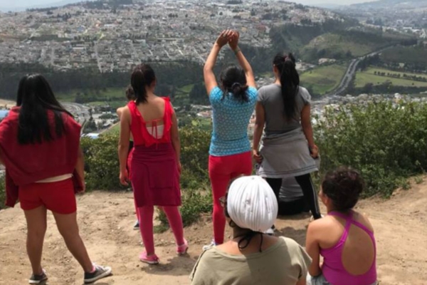 Group of young women looking out over a city from a hillside viewpoint during a young womens health internship.