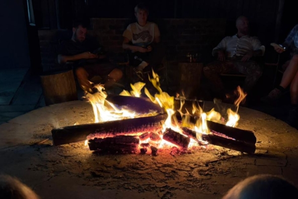 Research interns gathered around campfire at conservation field site.