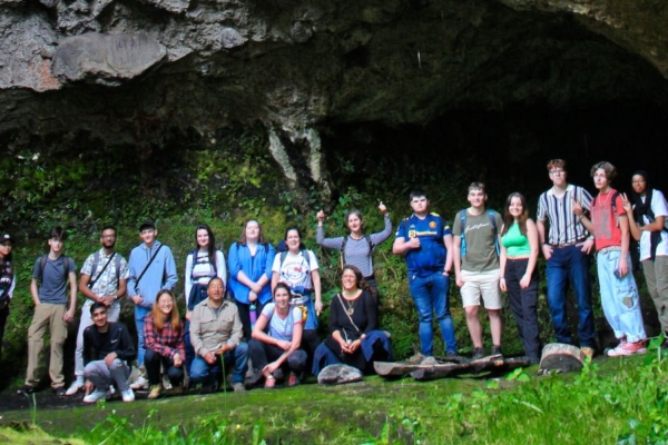 Art Therapy Internship group exploring a large natural cave formation as part of experiential learning and reflection in a natural environment.