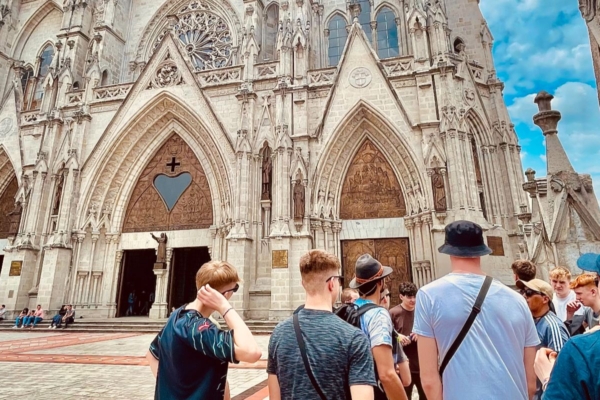 Group of youth gathered in a public square in front of a historic cathedral during a young womens health internship.