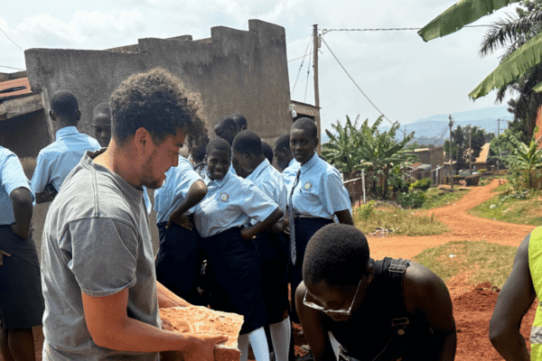 A large group of adults and students moving rocks.
