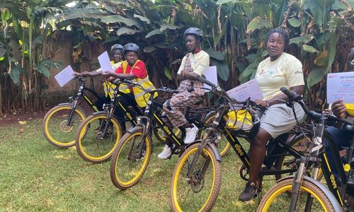 Several women holding certificates on e-bikes.