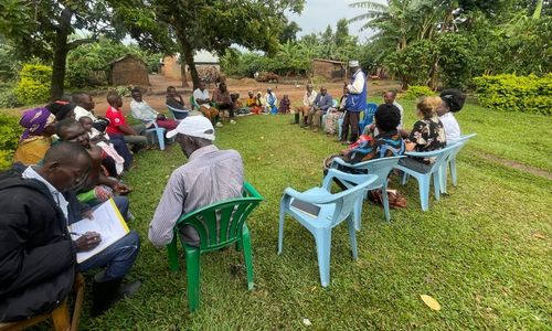 A group of people gathered in a circle outside.