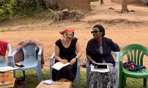 Two women sitting in chairs outside.
