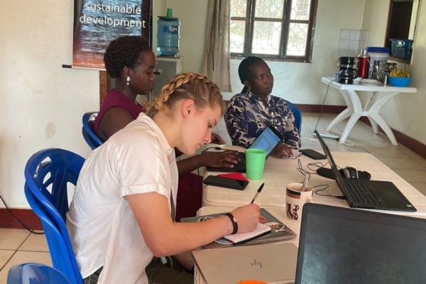 An intern and two staff members working at a table.